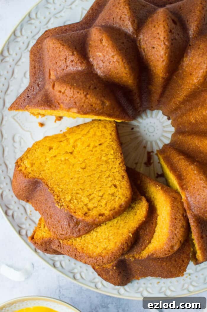 A close-up view of several thick slices of vegan mango bundt cake artfully arranged, showcasing its soft, moist, and airy texture with a beautiful golden hue.