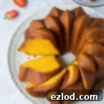 Sliced vegan mango bundt cake on a white plate.