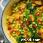 Close up of a cast iron pan of easy vegan lemongrass coconut curry with broccoli, tofu and edamame.