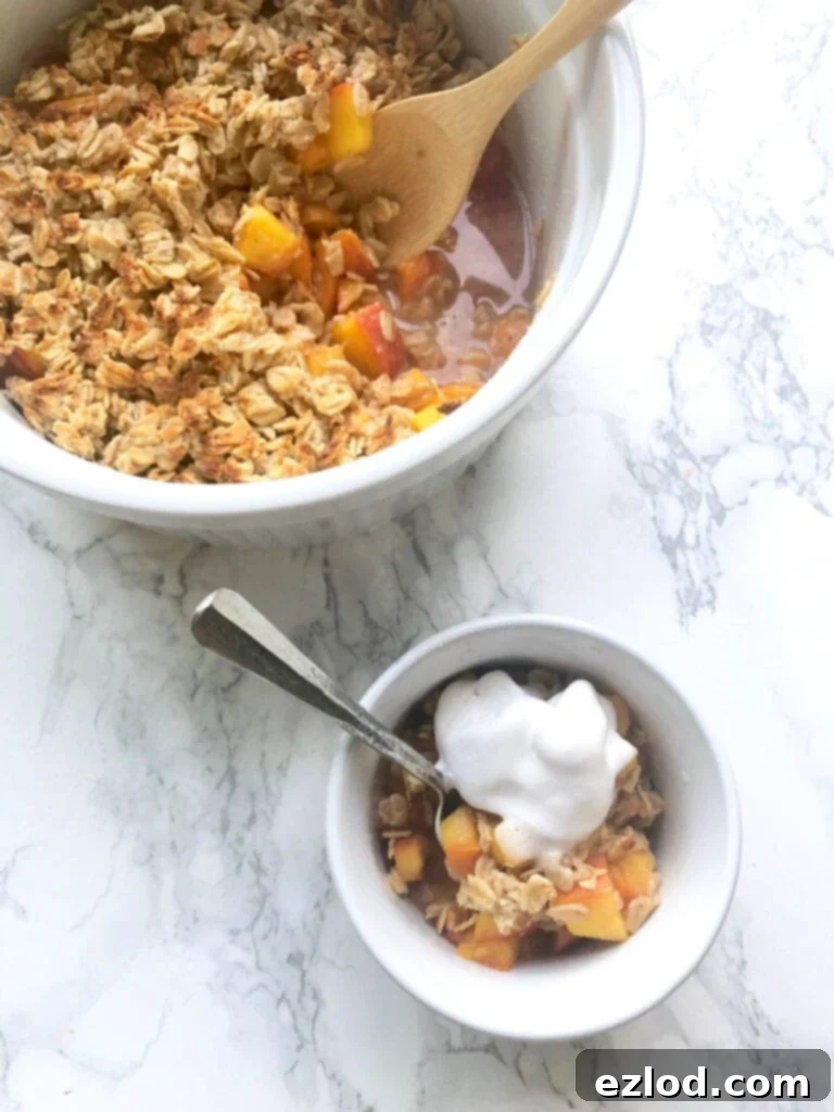 A small ramekin of Instant Pot peach crisp sitting in front of a larger bowl of Peach Crisp