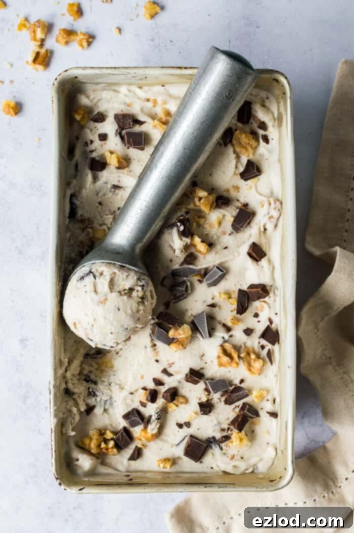Vegan chunky monkey ice cream in a metal loaf tin with an ice cream scoop.