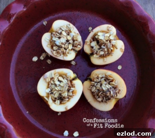 Two healthy baked apple halves, garnished with a sprinkle of cinnamon, ready to be served. Ideal for a healthy breakfast or dessert.