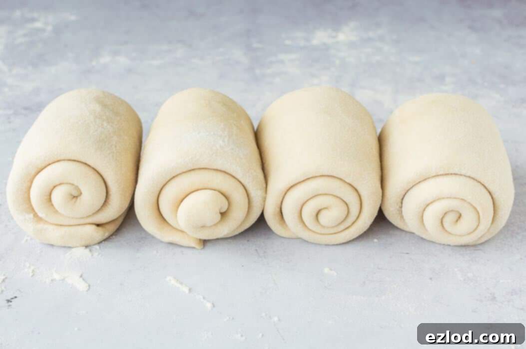 The shaped rolls of vegan Hokkaido milk bread dough neatly arranged in a loaf tin, ready for their second rise.