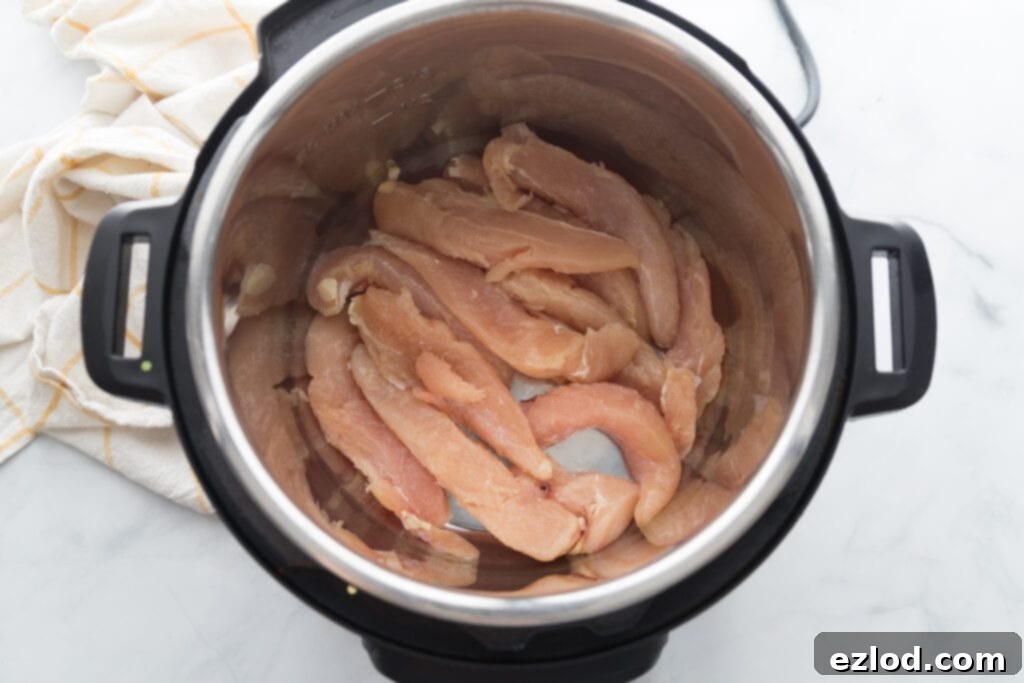 Raw chicken tenders in an instant pot, ready to be cooked
