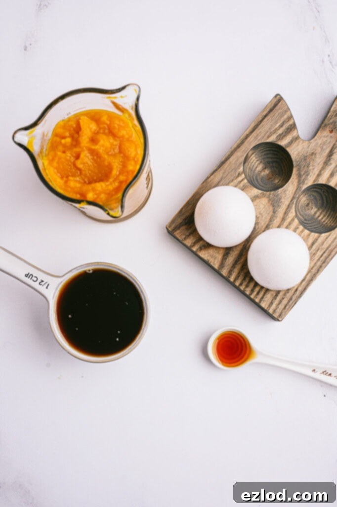 Overhead photo: individual ingredients to make pumpkin oatmeal muffins, on a white counter
