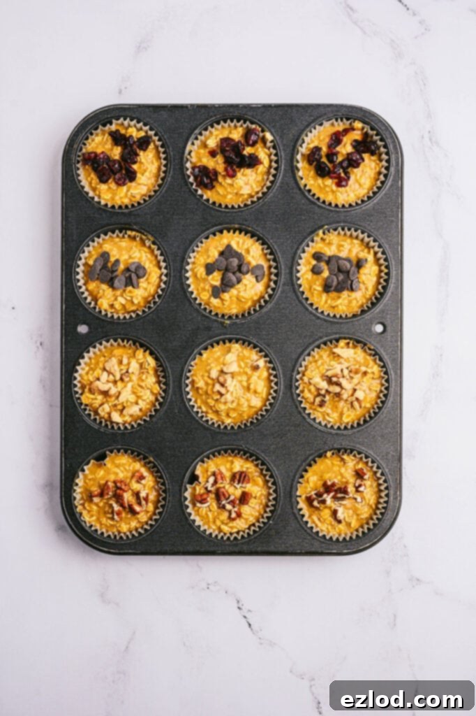 Overhead image: pumpkin oatmeal muffins with toppings, in a muffin tin