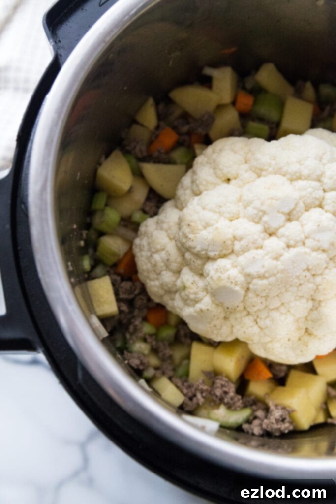 A head of cauliflower is added to cheeseburger soup to make it extra creamy without he dairy
