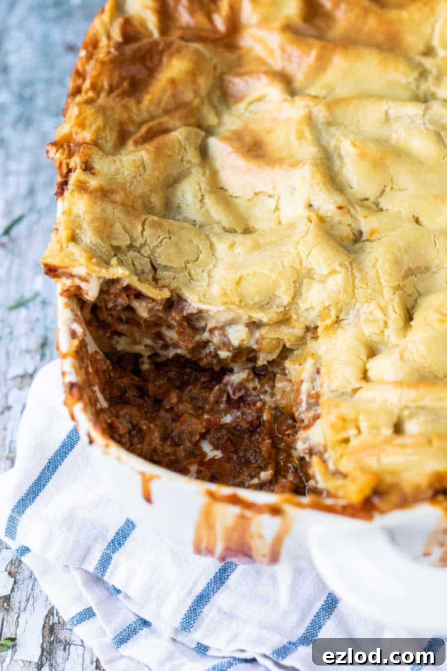 Classic vegan lasagne - this vegan lasagna is seriously good! A rich mushroom ragu is layered up with a creamy dairy-free bechamel sauce and sheets of pasta. It is hearty, filling, totally delicious and healthy too! #lasagna #veganmeals #veganlasagna #plantbased #dairyfree #meatfree close up of a dish of vegan lasagne with a slice removed.