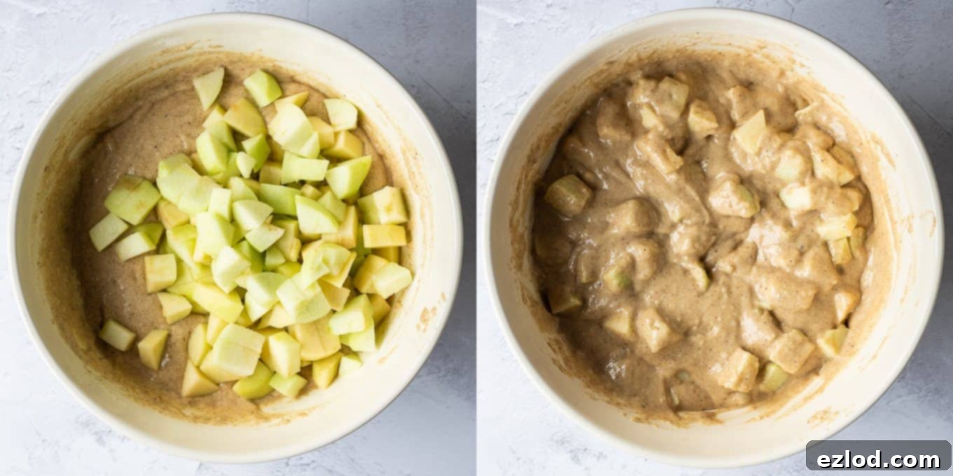 Step 2 in making vegan apple cake: diced apples being gently folded into the cake batter in a large bowl.