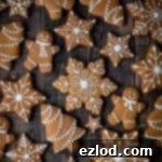 Festive Vegan Gingerbread Cookies 9 iced vegan gingerbread cookies on a dark wood background.