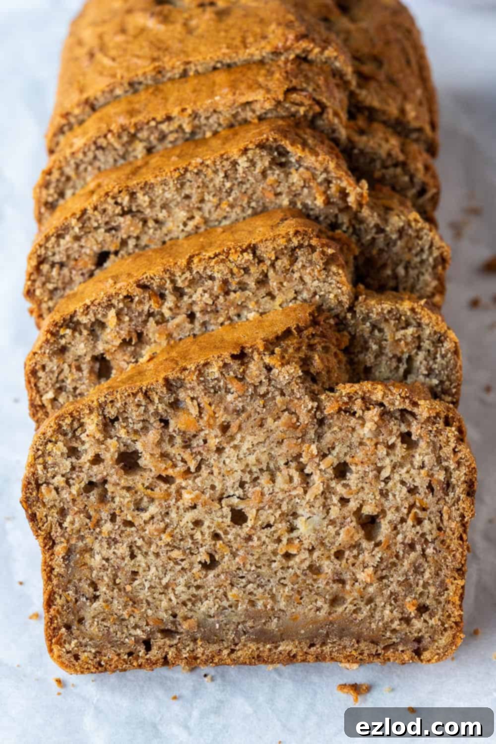 Sliced Vegan Carrot Banana Bread - Healthy Breakfast or Snack A row of perfectly cut slices of vegan carrot banana bread, showing the moist interior and flecks of carrot, ready to be enjoyed.