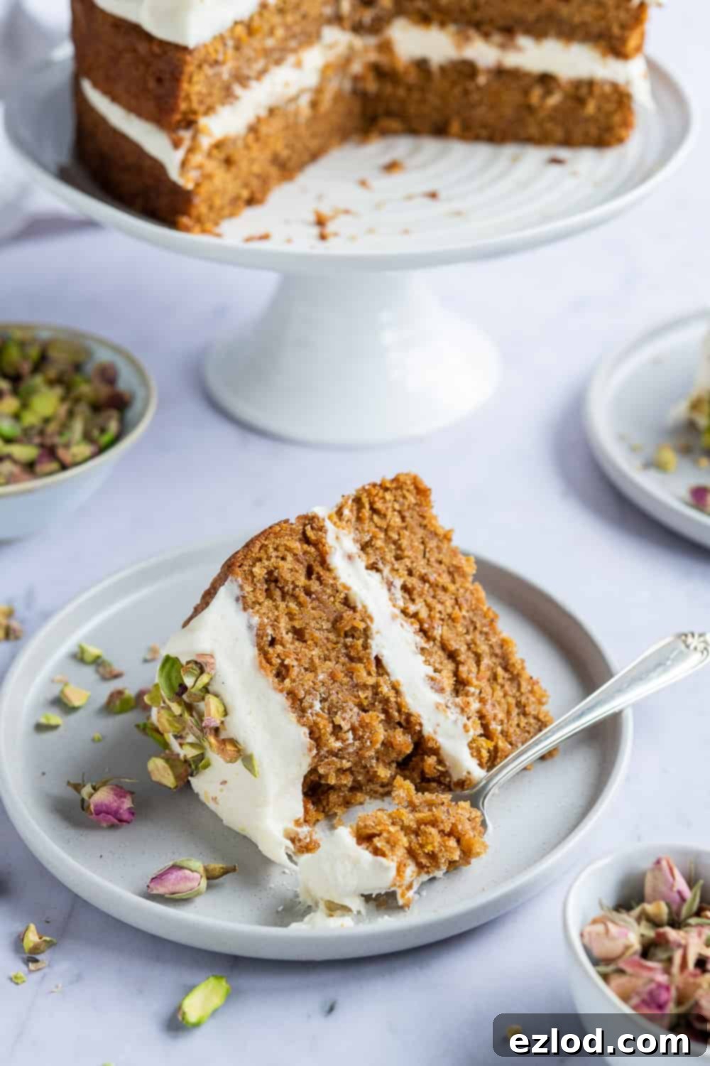 Delicious Slice of Vegan Carrot Cake A perfectly portioned slice of moist vegan carrot cake on a sophisticated grey plate, accompanied by a fork, showcasing its delightful layers and frosting.