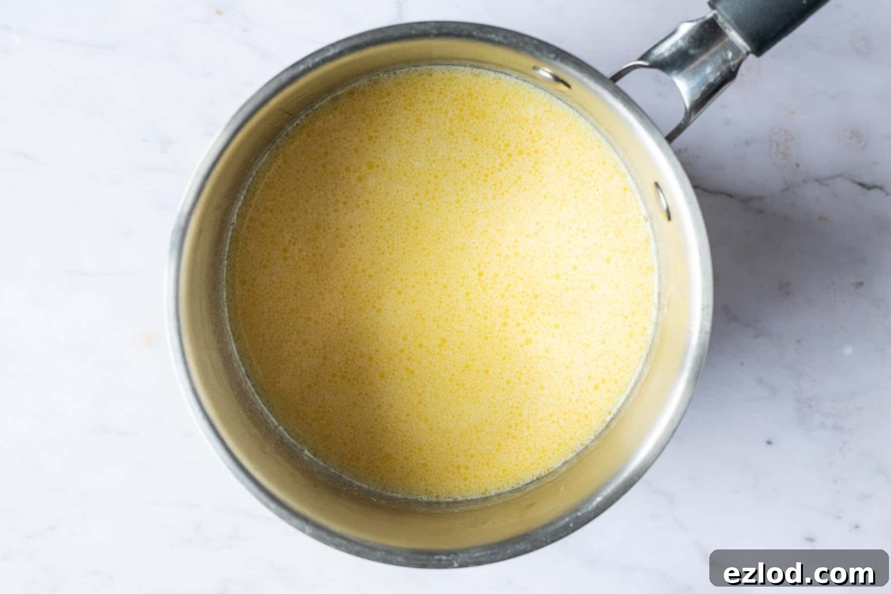 Sweet Spiced Vegan Buns 3 Step 2: Melting vegan butter in a saucepan, ready to be combined with non-dairy milk for the wet ingredients of vegan hot cross buns. Crucial for a dairy-free recipe.