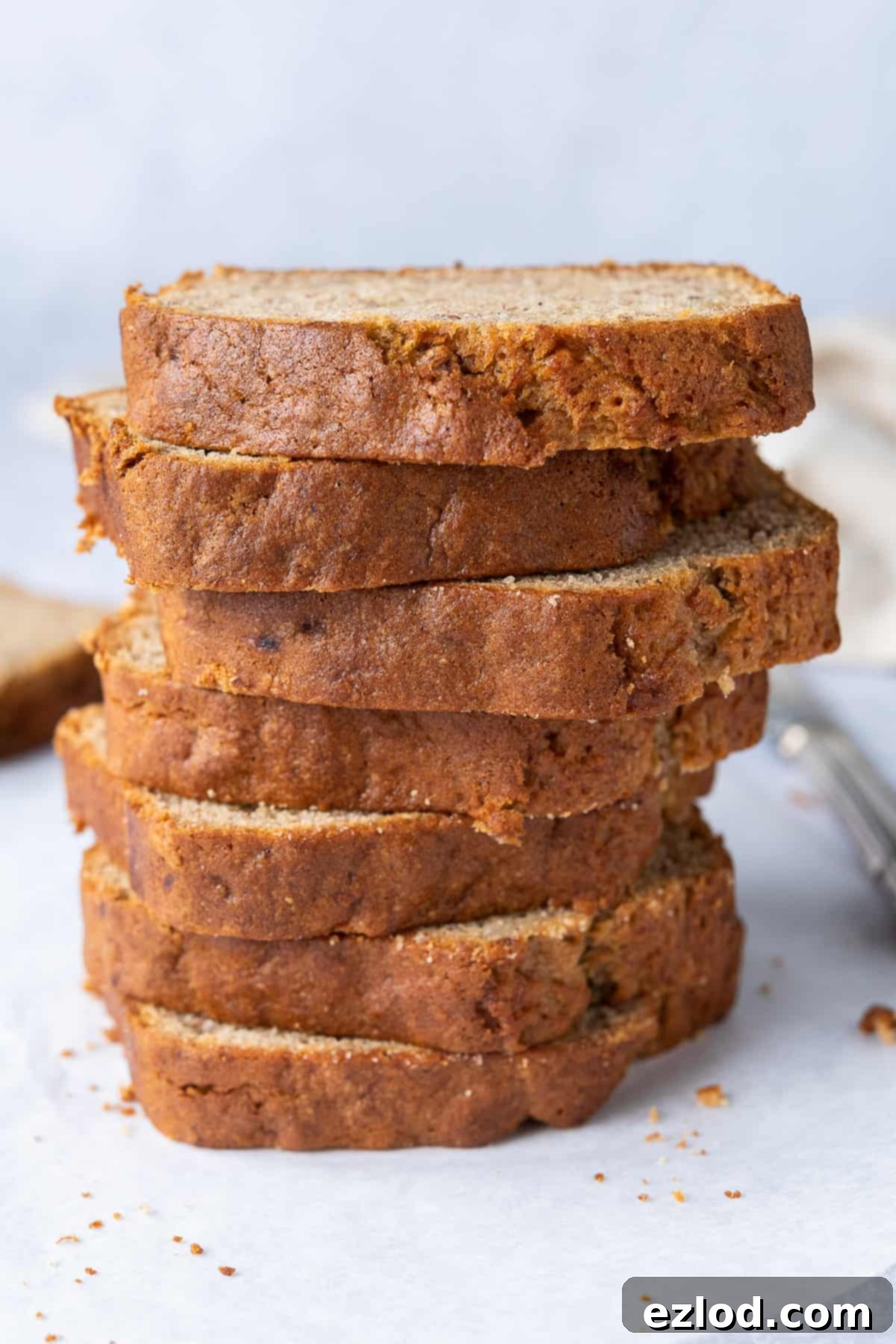Perfectly Stacked Slices of Moist Vegan Banana Bread A beautifully presented stack of freshly sliced easy vegan banana bread, showing off its golden crust and moist, tender interior.