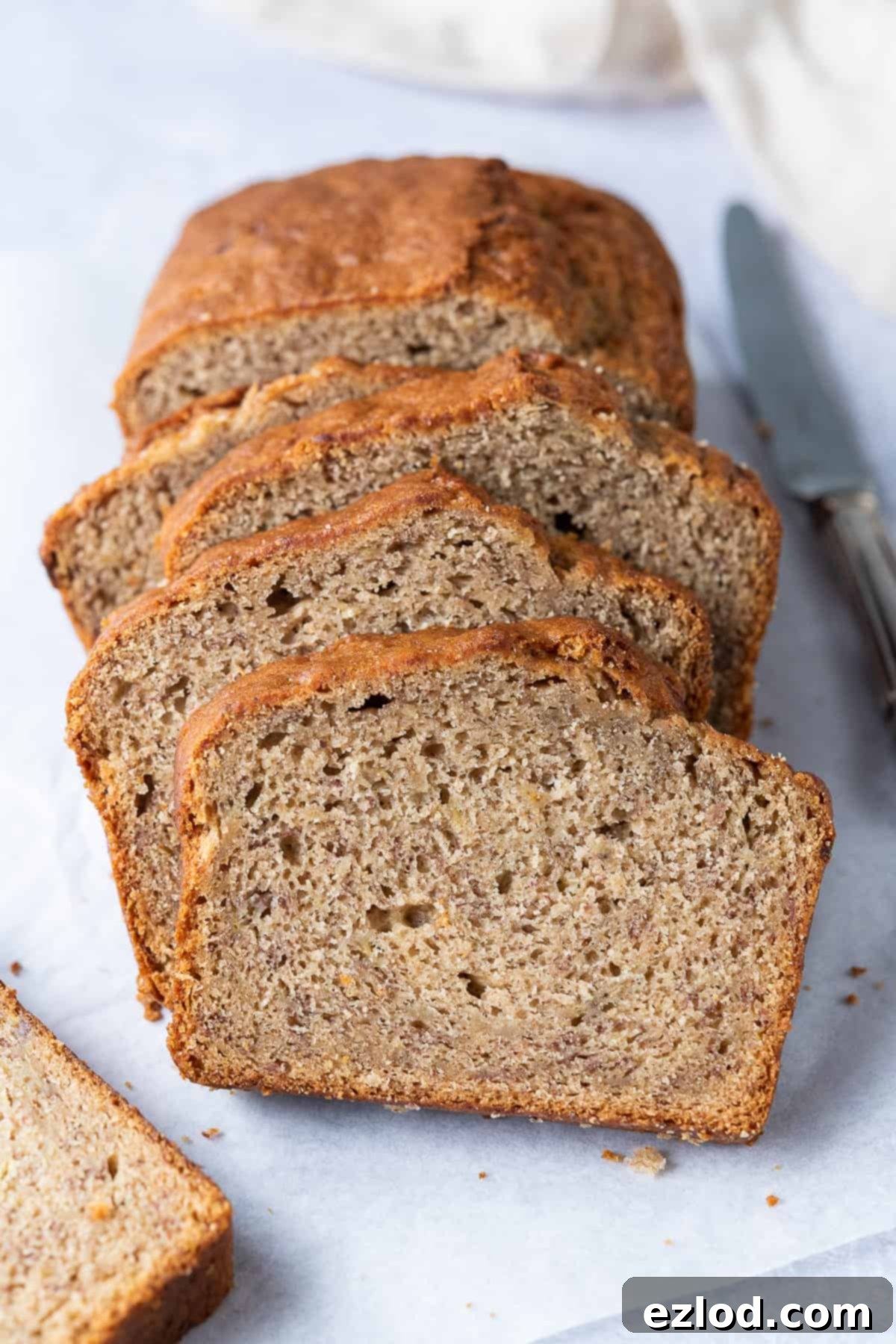 Delectable Row of Slices from the Best Vegan Banana Bread A beautiful row of freshly baked vegan banana bread slices, perfectly arranged on a serving board.