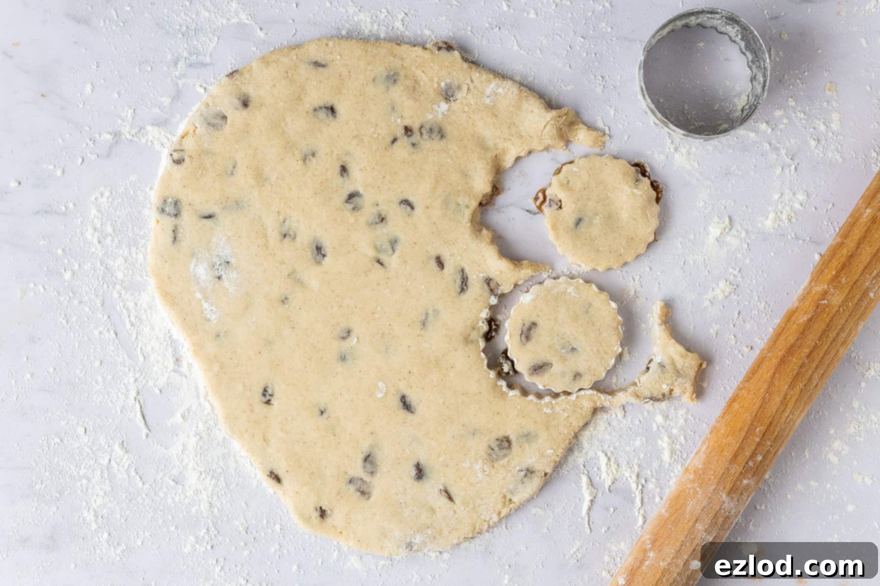 Heavenly Vegan Welsh Cakes 4 Vegan Welsh cake dough being rolled out and cut into fluted rounds on a lightly floured surface.