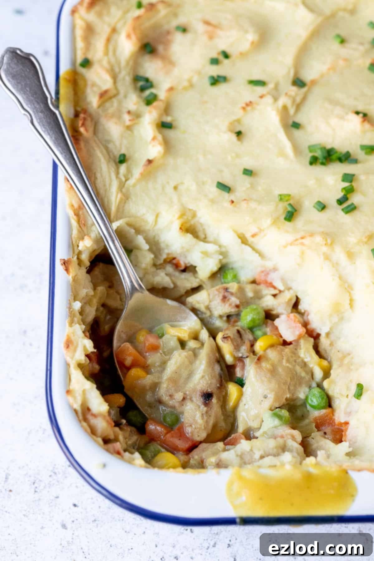 Delicious vegan chicken potato pie, showcasing the rich filling and golden mashed potato. A perfect dairy-free, meat-free dinner option. Close-up shot revealing the creamy texture of the vegan chicken and vegetable filling beneath the golden mashed potato crust of the pie.