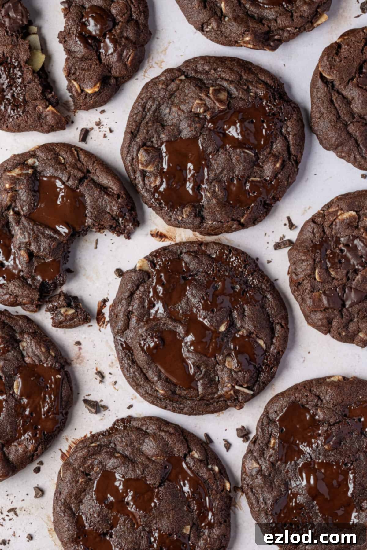 Vegan double chocolate almond cookies – these rich, intensely chocolatey cookies are easy to make and taste amazing! They are crisp around the edges, gooey in the middle and are filled with chocolate chunks and almonds for an indulgent treat. Double chocolate almond cookies on a marble surface.