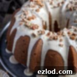 Cozy Vegan Pumpkin Bundt Delight 9 Close up of vegan pumpkin bundt cake with maple glaze and chopped pecans.