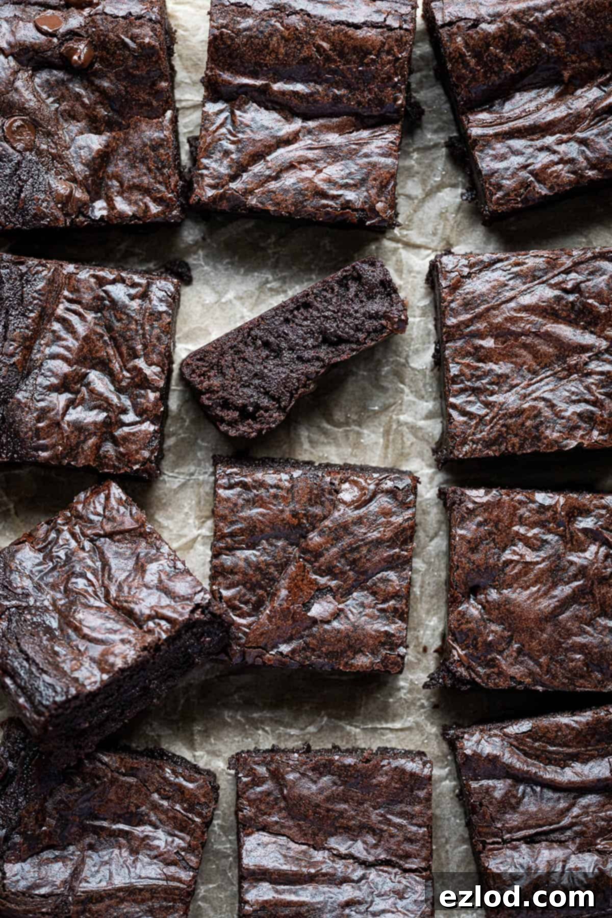 Seriously Fudgy Plant-Powered Brownies 2 Close up of fudgy vegan brownies, one on it's side, showcasing the rich chocolate interior and shiny top.