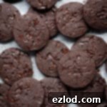 Vegan chocolate orange shortbread cookies on white baking parchment.