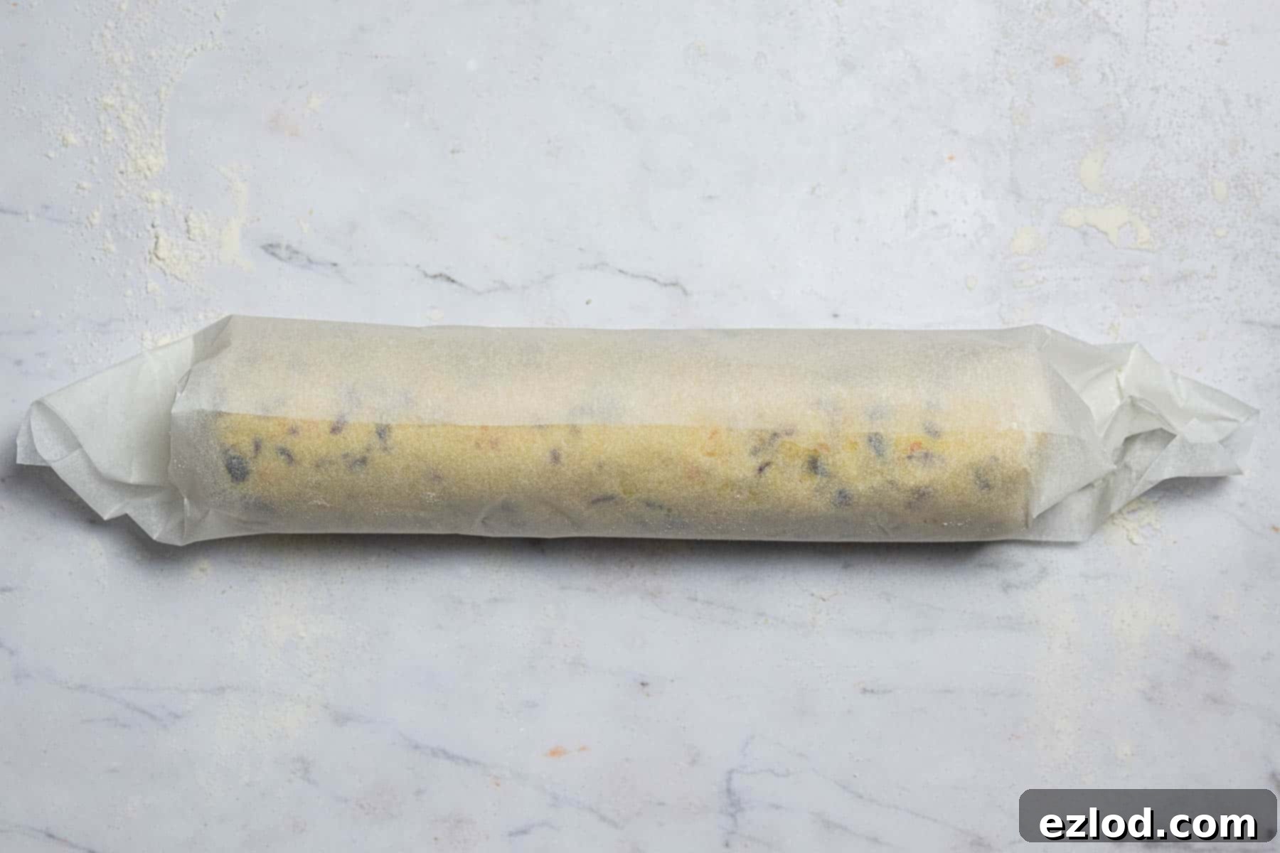 Vegan Zesty Cranberry Orange Shortbread 8 Step 5: Wrapping the shaped vegan shortbread dough log in baking parchment for refrigeration.