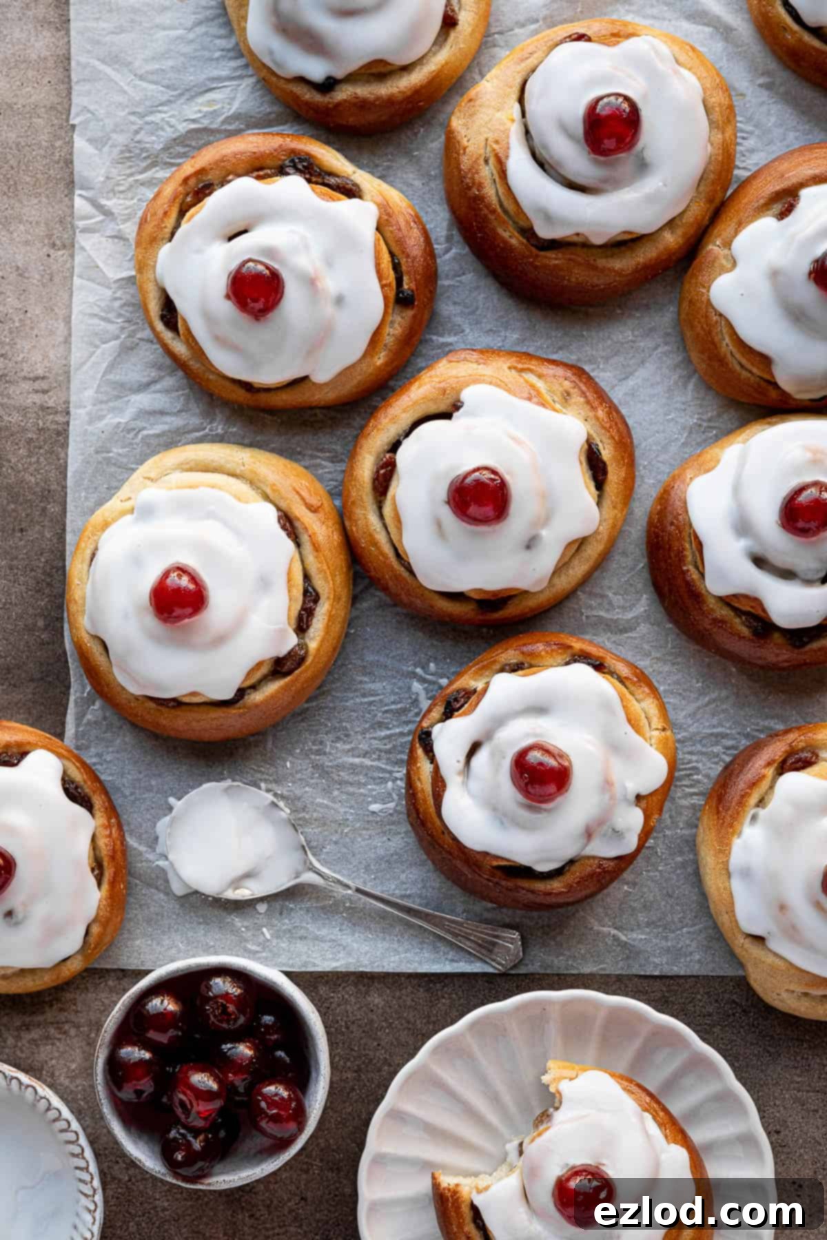 Plant-Based Belgian Delights 2 Vegan Belgian buns on a sheet of baking parchment with a bowl of glace cherries.