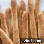 Aromatic Plant Sticks 12 Close up of herby vegan breadsticks on baking parchment, freshly baked.