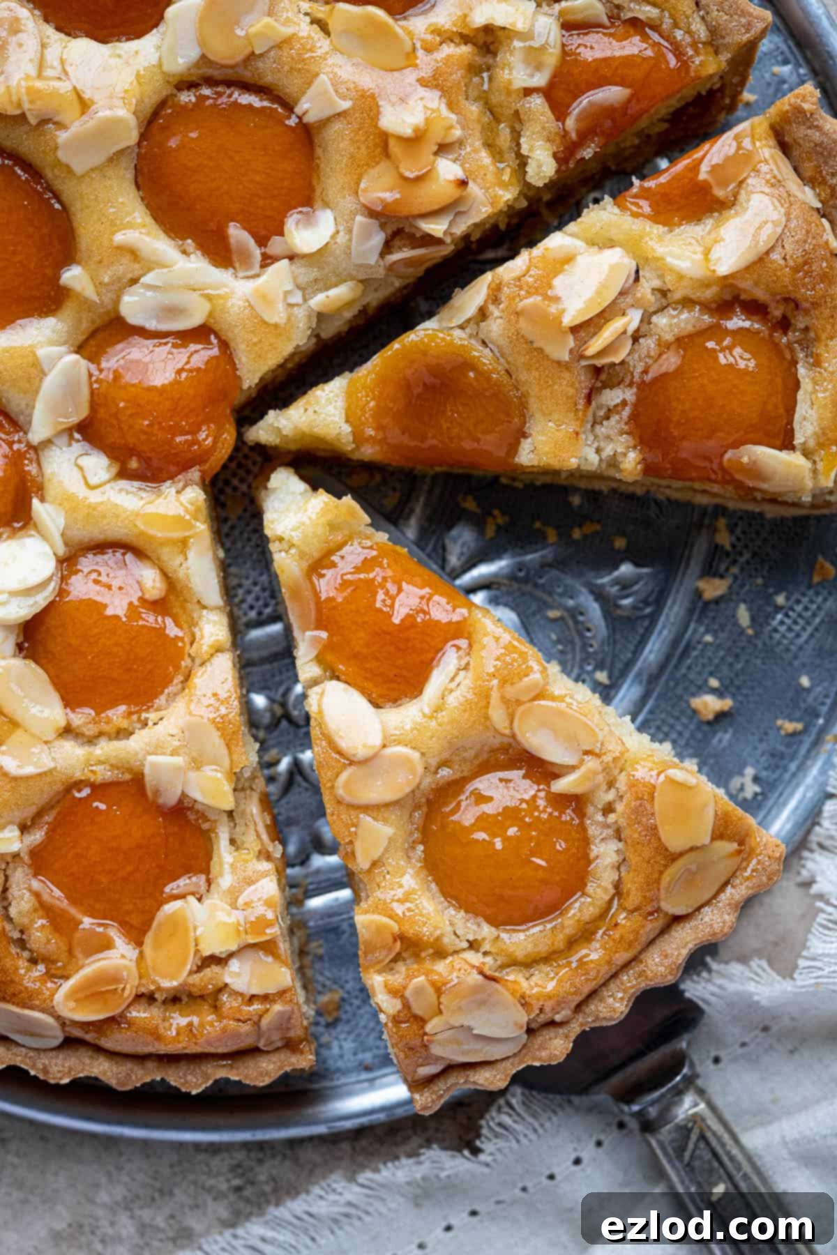 Plant-Based Apricot Frangipane Tart 12 Close-up of a generously sliced vegan apricot frangipane tart, showing the interior and crust texture.
