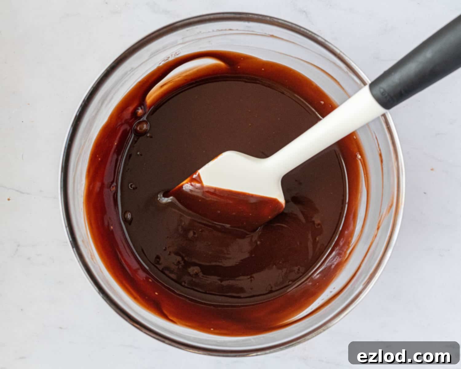 Decadent Vegan Chocolate Hazelnut Cake 11 The rich vegan chocolate hazelnut ganache, now perfectly melted and smooth after combining hot cream and chopped chocolate, glistens in a heatproof bowl.