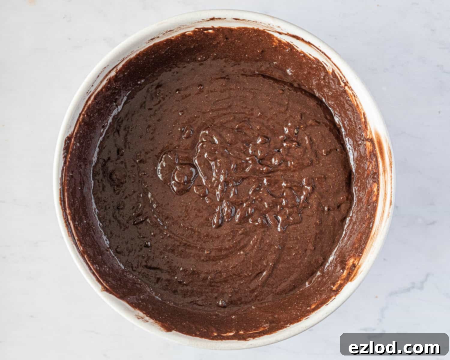 Decadent Vegan Chocolate Hazelnut Cake 7 The perfectly mixed vegan chocolate hazelnut cake batter in a bowl, smooth and ready to be poured into the baking tin, demonstrating the ideal consistency before baking.