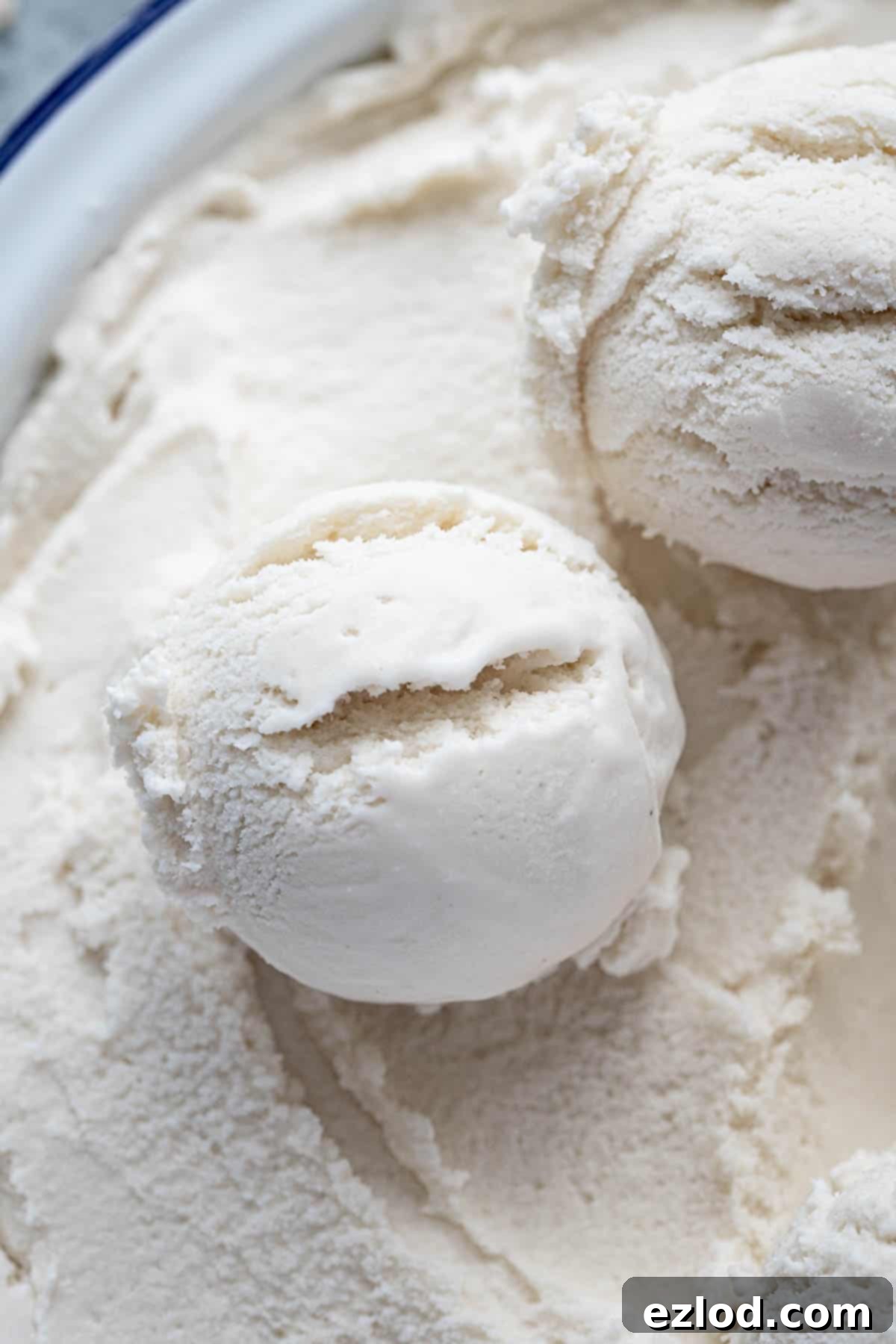 Effortless Vegan Coconut Ice Cream 6 Close up of a single scoop of vegan coconut ice cream, showing its smooth texture and subtle flecks of vanilla/nutmeg.