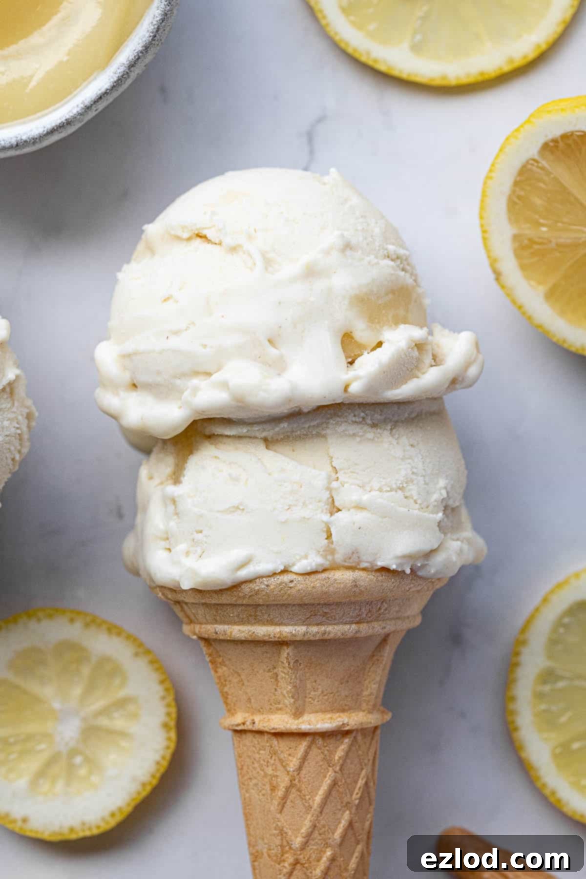 Refreshing Vegan Lemon Delight 10 A close-up of two perfectly scooped portions of vegan lemon ice cream nestled in a crisp waffle cone, ready to be enjoyed.