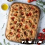 Baking Bliss and BBC Maestro Insights 15 Tomato olive focaccia surrounded by herbs, tomatoes and bowls of olives, salt and olive oil.