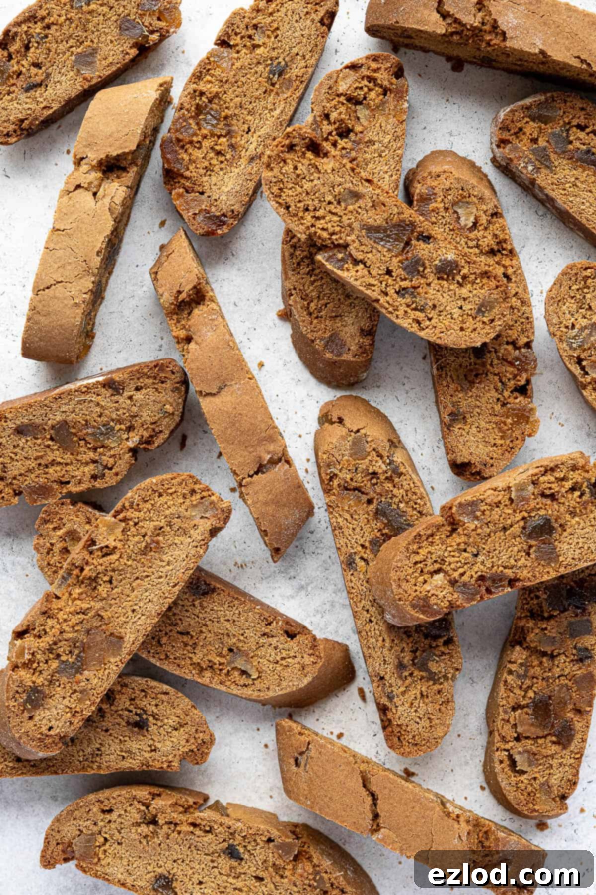 Warmly Spiced Vegan Gingerbread Biscotti 3 Vegan ginger biscotti on a white surface.