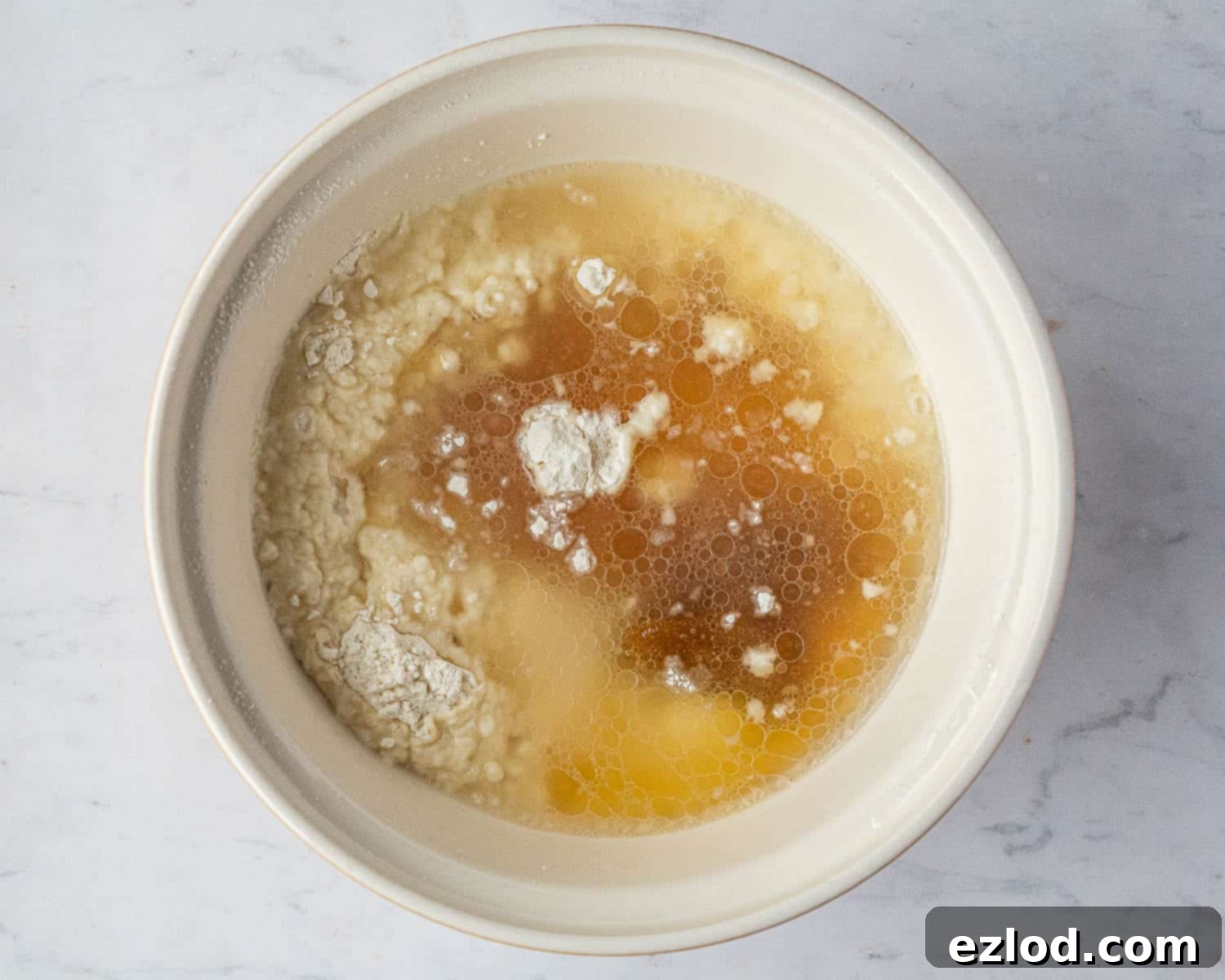 Vegan Liquid Gold Cake 5 Step-by-step image showing all the vegan golden syrup cake ingredients gathered in a large mixing bowl, before stirring.