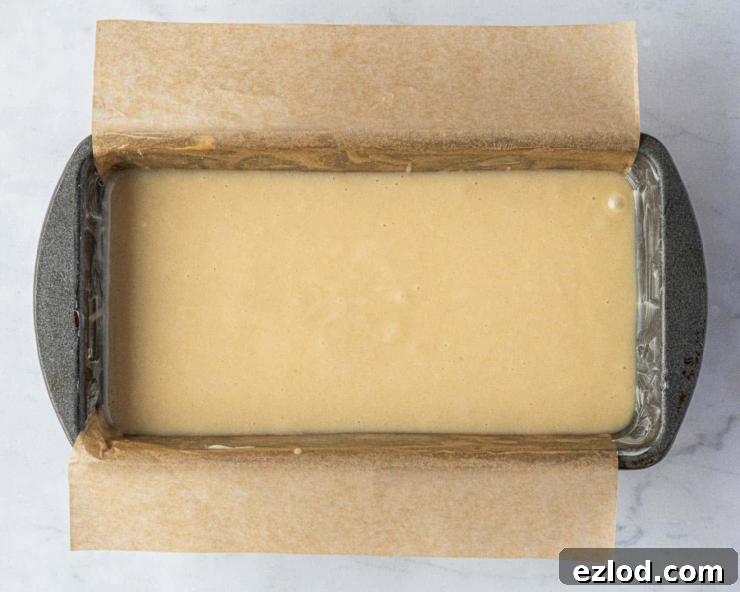 Vegan Liquid Gold Cake 7 Step-by-step image showing the smooth vegan golden syrup cake batter poured into a greased and lined loaf tin, ready to be baked.