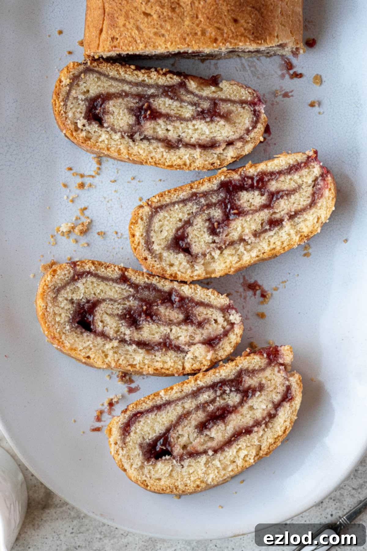 Luscious Vegan Jam Roly-Poly 15 Beautifully sliced pieces of vegan jam roly-poly arranged artfully on a plate, showcasing the vibrant jam swirl.