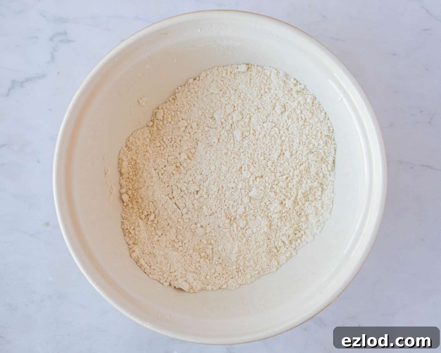 Luscious Vegan Jam Roly-Poly 4 Step 1 in making vegan jam roly-poly: rubbing cold vegan butter into self-raising flour and salt with fingertips until it resembles fine breadcrumbs.