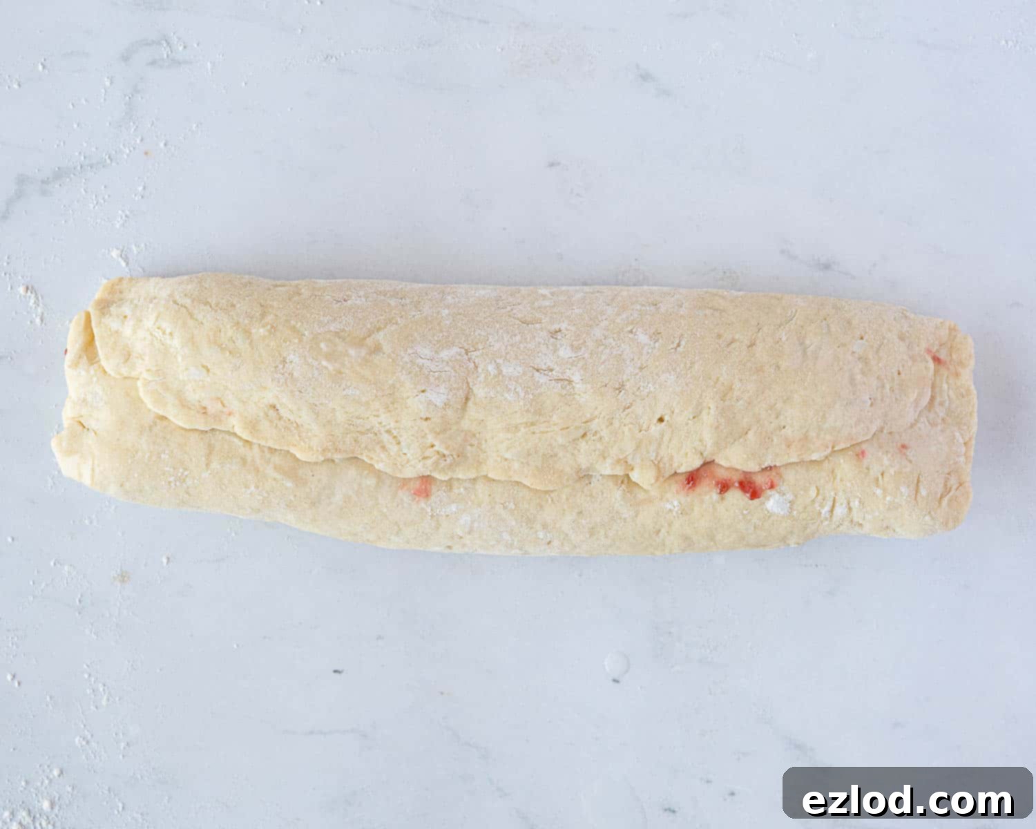Luscious Vegan Jam Roly-Poly 10 Step 7 in making vegan jam roly-poly: the finished log of pastry, with the seam brushed with water and sealed, and the ends pinched closed.