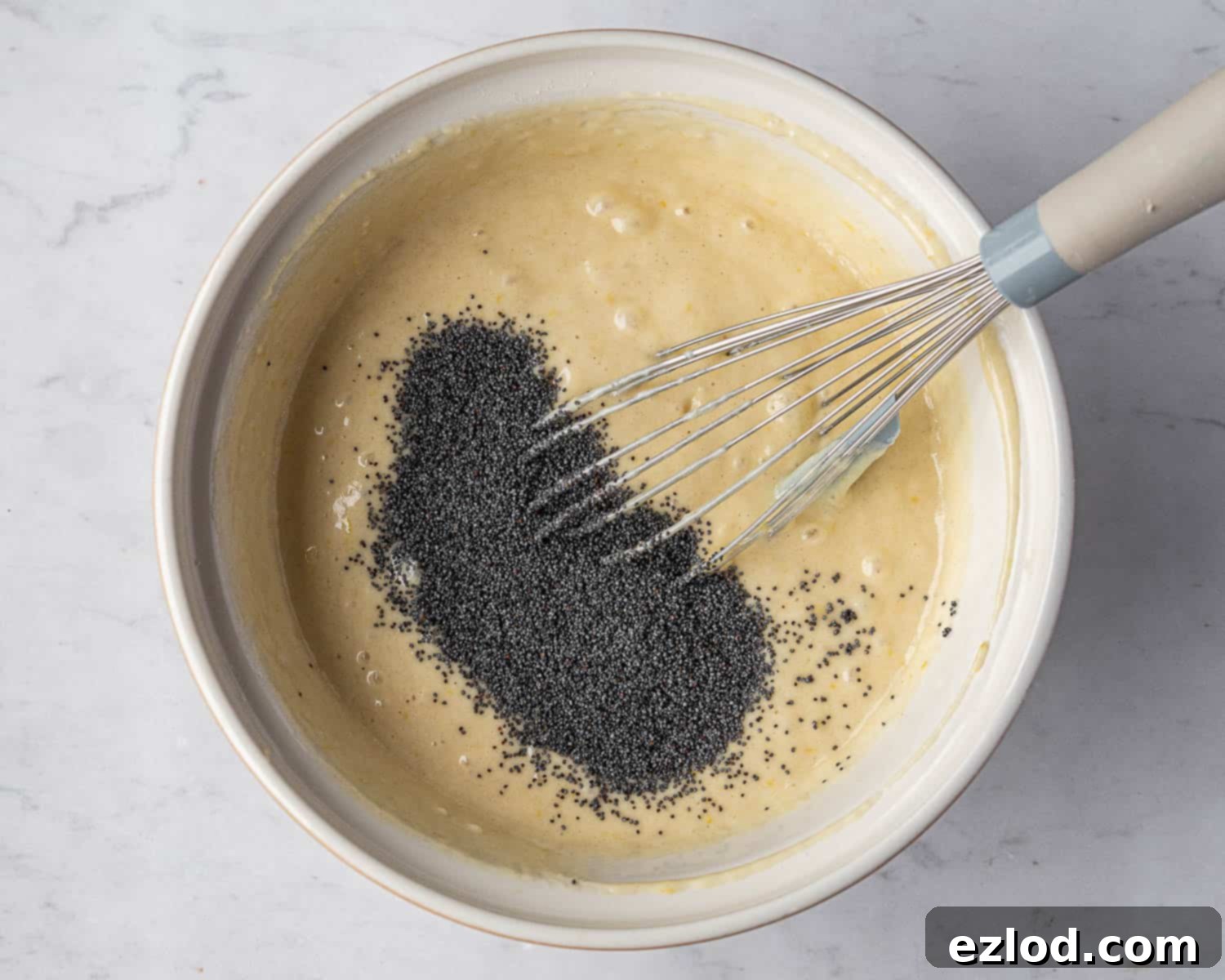 Zesty Vegan Lemon Poppy Seed Cake 7 Step 3: The finished cake batter, smooth and ready, with poppy seeds visibly folded into the mixture, sitting in a large bowl.