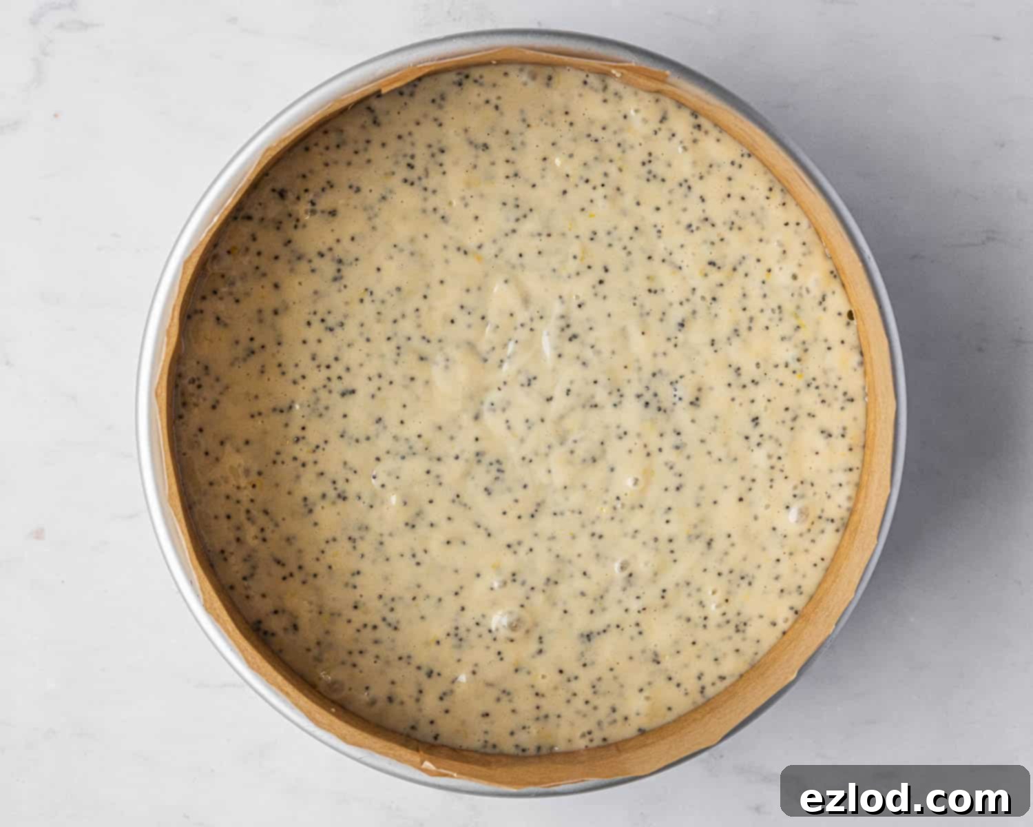 Zesty Vegan Lemon Poppy Seed Cake 8 Step 4: The smooth cake batter has been poured into a prepared 20 cm round cake tin, ready for baking.