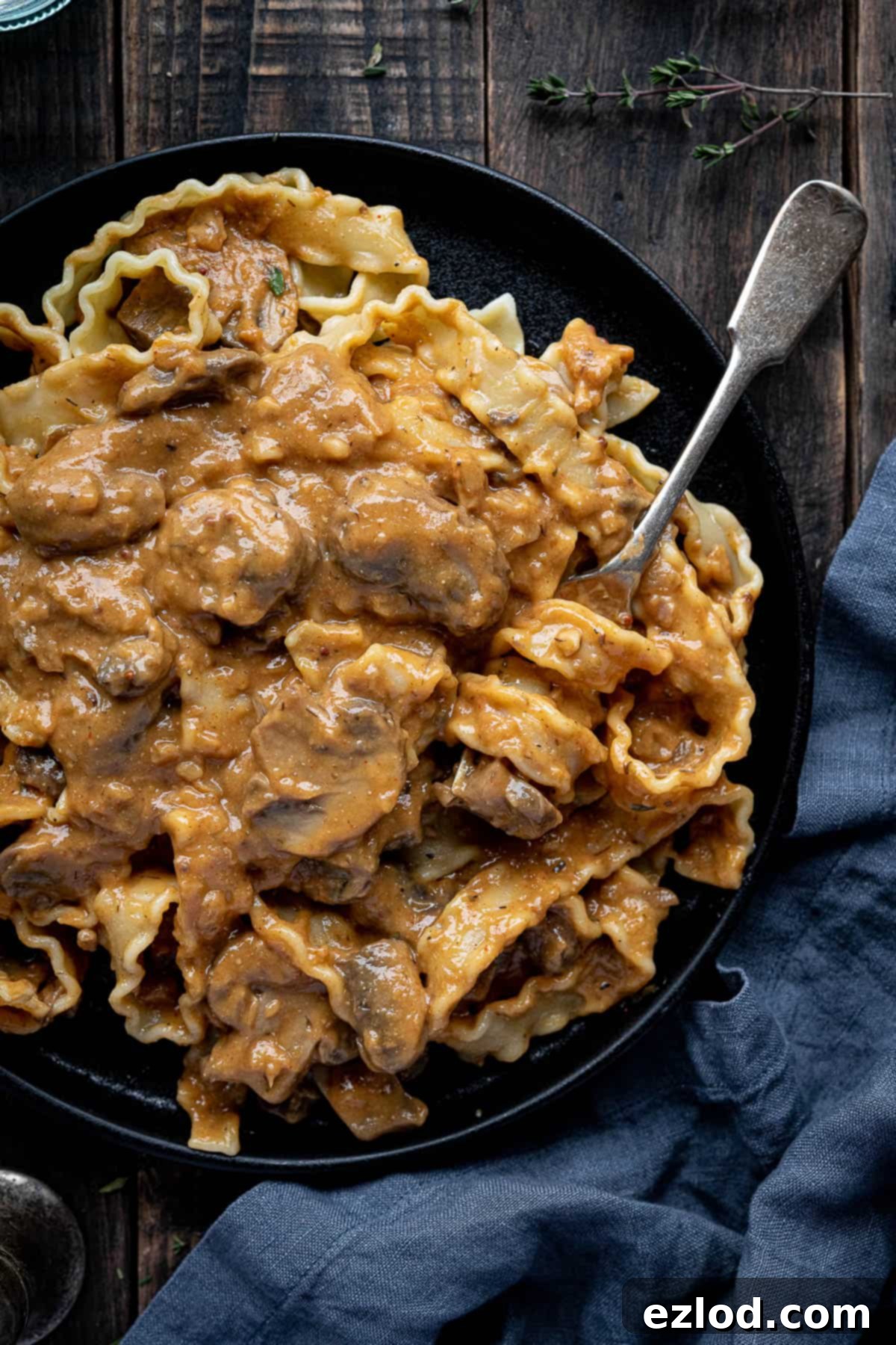 Creamy Vegan Mushroom Stroganoff 3 Mushroom stroganoff pasta on a black plate with a fork.