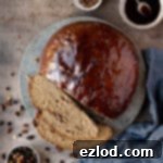 Jamaican Plant-Based Spiced Bun 13 Jamaican spice bun on a stone plate with bowls of glaze, fruit and spice.