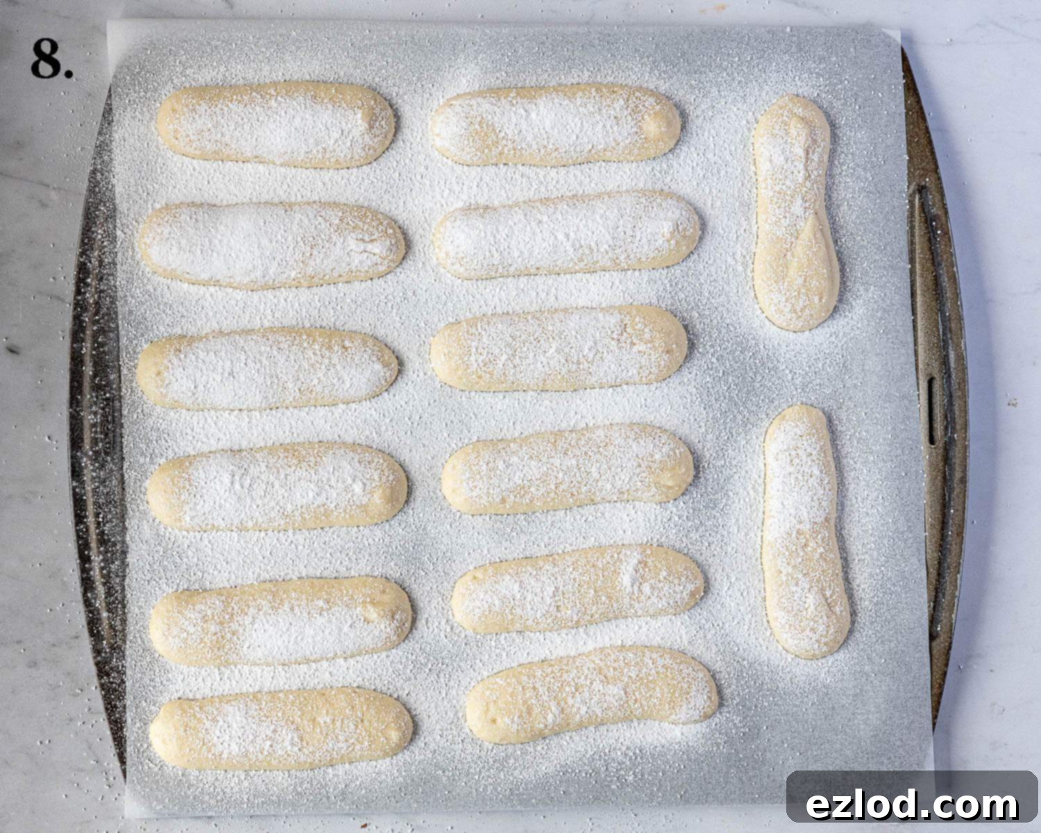 Delicate Vegan Ladyfingers 11 Step 8 of the recipe: Piped ladyfingers on a baking sheet, generously dusted with caster and icing sugar.