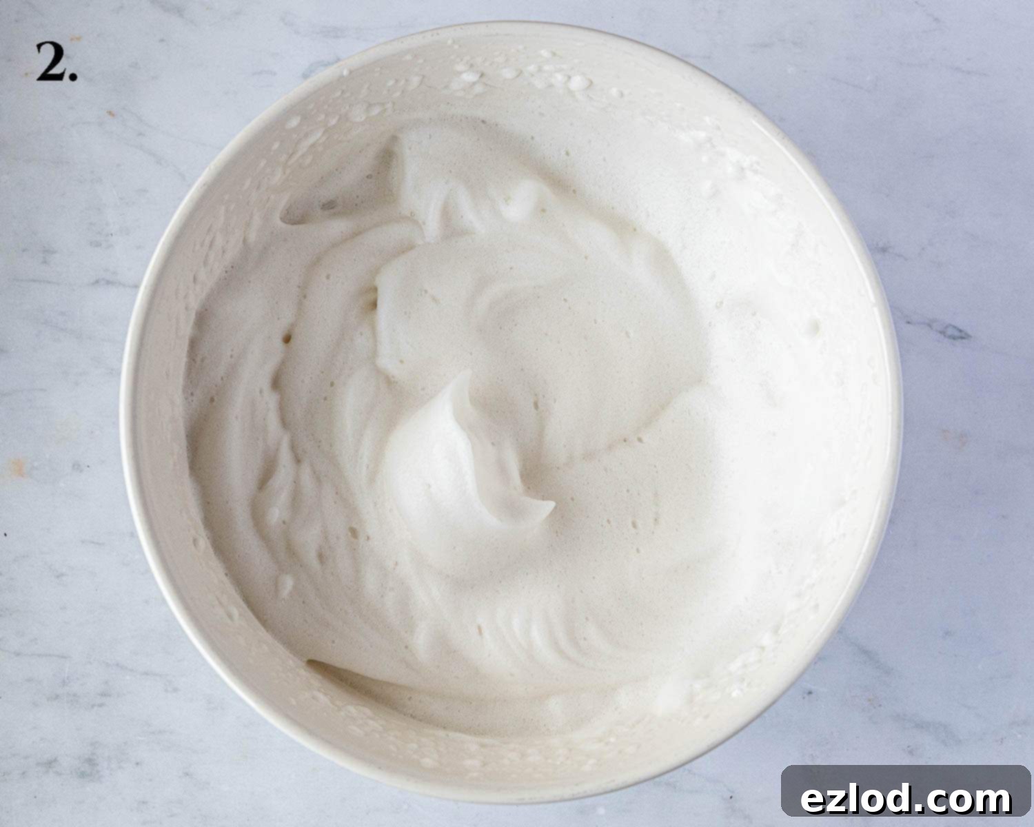 Delicate Vegan Ladyfingers 5 Step 2 of the recipe: Aquafaba is whisked to a soft, foamy consistency with gentle peaks.