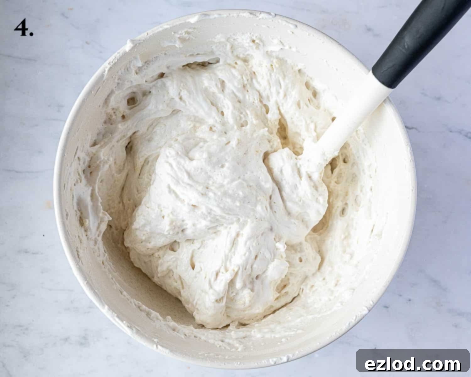 Delicate Vegan Ladyfingers 7 Step 4 of the recipe: Half of the dry ingredients have been gently folded into the meringue, showing some dry patches.