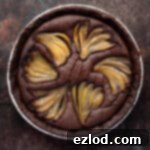Rich Vegan Chocolate Pear Almond Tart 16 The baked chocolate pear frangipane tart on a dark surface.