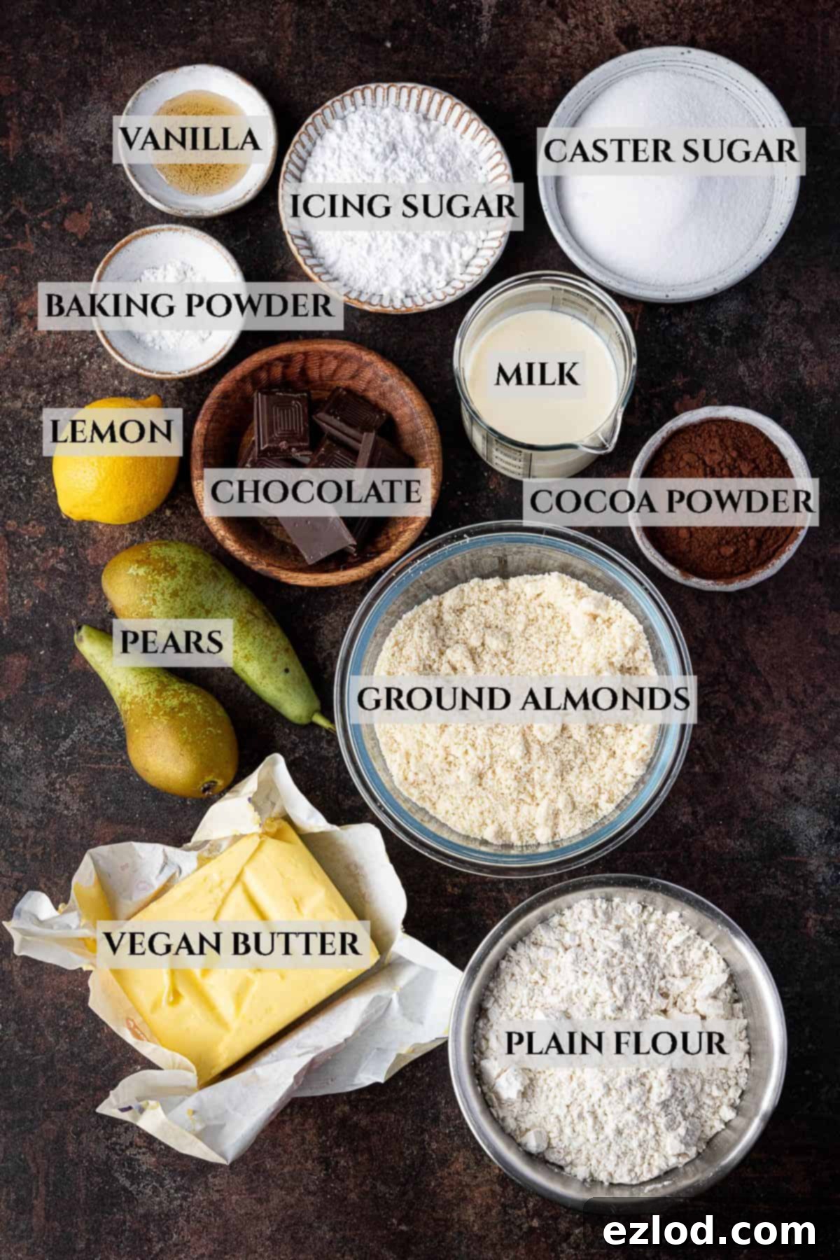 Rich Vegan Chocolate Pear Almond Tart 3 An array of ingredients laid out in bowls for making the vegan chocolate pear frangipane tart, clearly labelled for easy identification.
