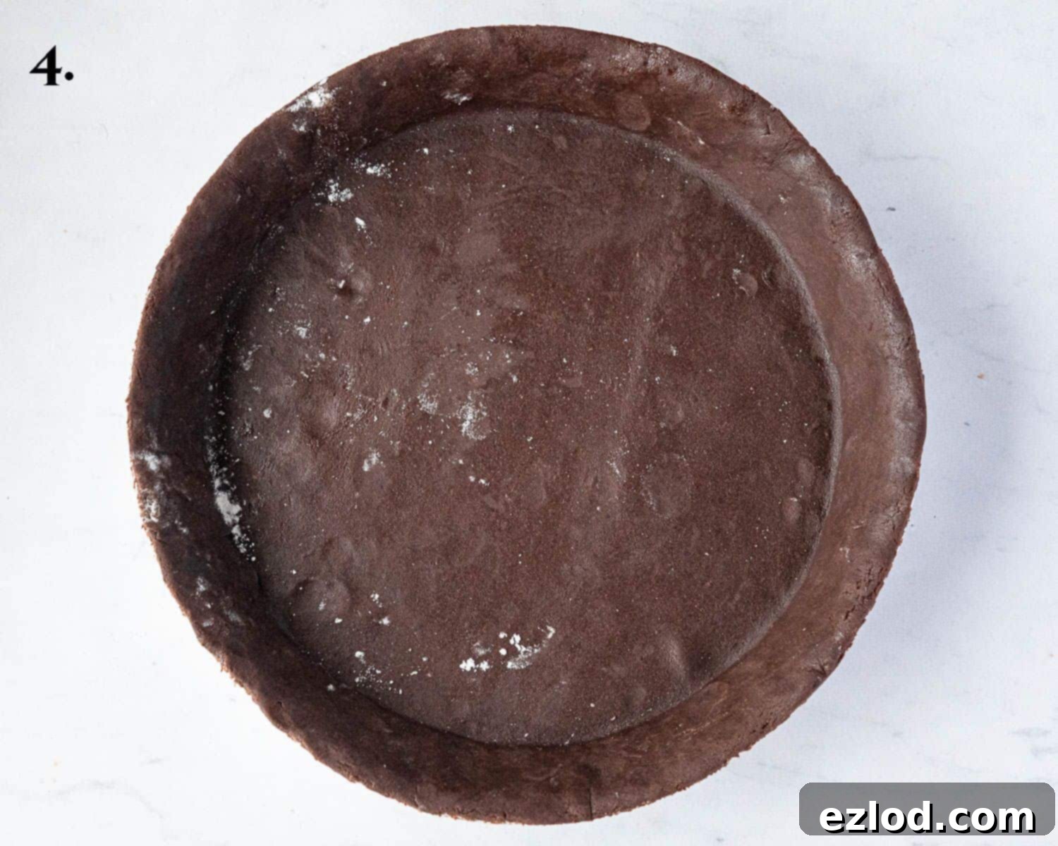 Rich Vegan Chocolate Pear Almond Tart 8 Step-by-step image depicting the chocolate pastry successfully lined in a pie dish, ready for blind baking.